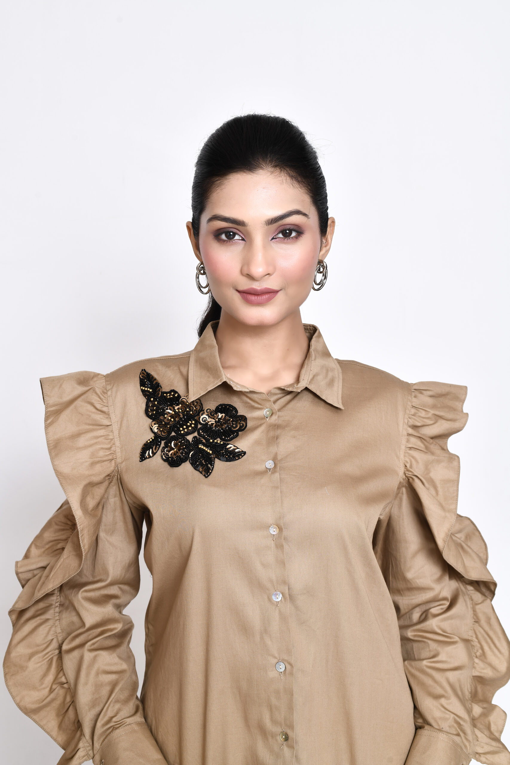 Golden Muslin Jaanvi Mohta beige cotton twill shirt with floral embellishments and cut-out exaggerated sleeves