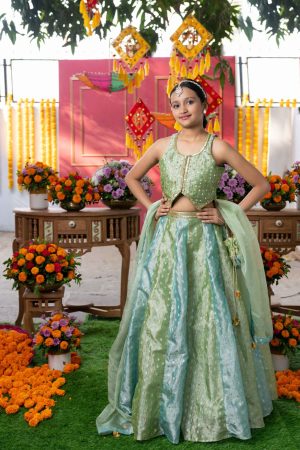 Pastel green tissue silk girls’ lehenga choli set with golden sequin and zari embroidery, matching flared lehenga, net dupatta, and embroidered potli – Golden Muslin