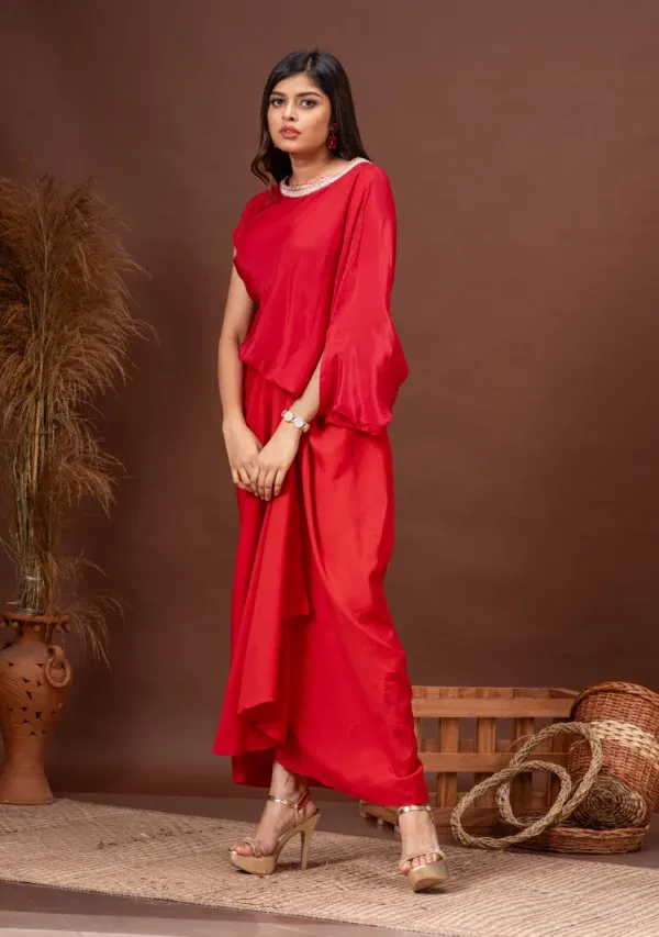 Tomato red silk top with asymmetric sleeves and draped skirt by Kumar Rahul from the house of Golden Muslin.