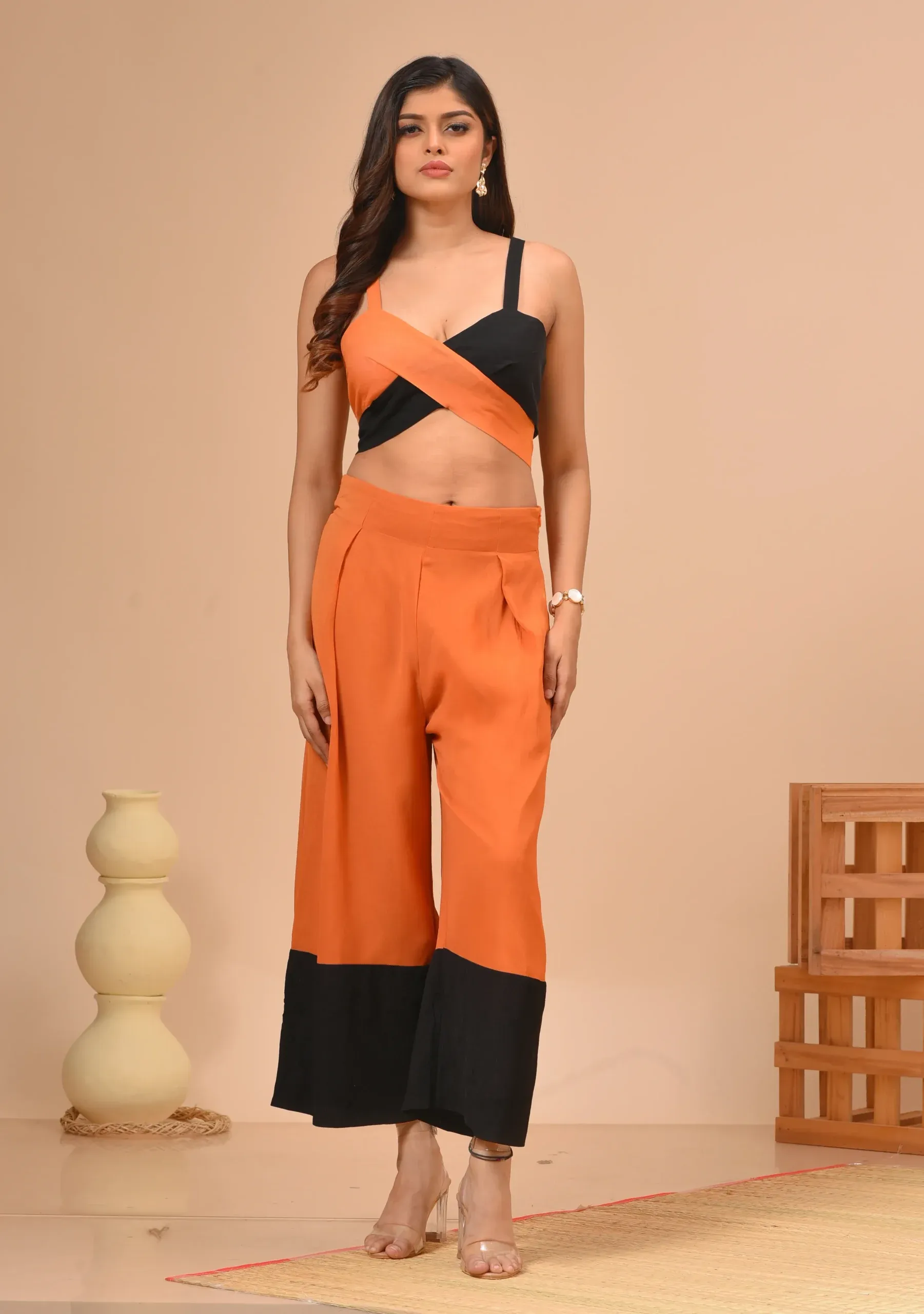 Black and orange georgette crisscross strappy bustier and pleated culottes from the house of Golden Muslin by Kumar Rahul.
