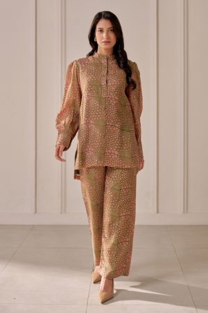 “Golden Muslin olive green muslin silk mandi block-printed shirt with petal-shaped yoke, stand collar, concealed placket, uneven hem, paired with tailored straight-leg trousers.”
