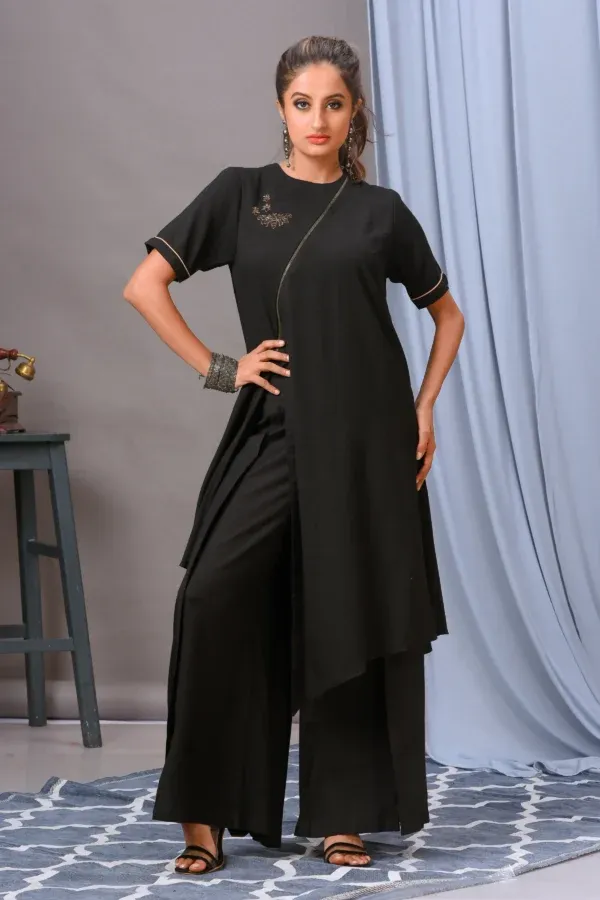 A black cotton rayon front-open asymmetric tunic from Golden Muslin By Vivek Kumar, featuring minimal hand embellishments and paired with chic black pants.