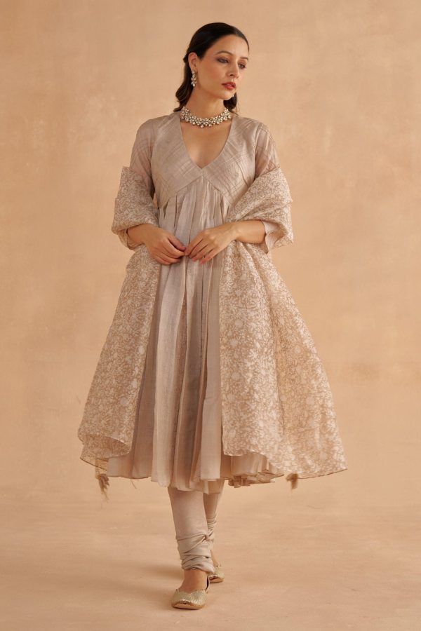 Golden Muslin warm Paper Tussar Kalidar kurta with pin-tuck checks, embroidered motifs, zardozi bels, paired with grey Chanderi churidar and block-printed organza dupatta.