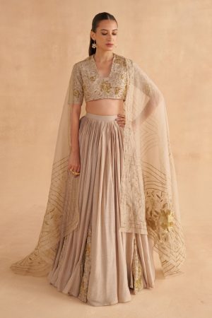 Golden Muslin warm grey Moonga silk lehenga set with deep V-neck Zardozi-embroidered blouse, floral jaal work, and embroidered organza dupatta.