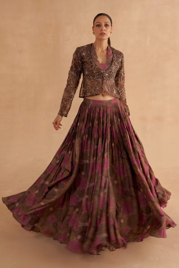 “Golden Muslin dark brown organza jacket with Zardozi and Mukaish lotus motifs, paired with walnut brown Moonga silk printed V-neck blouse and walnut brown lehenga with fagoting stitches and pockets.”