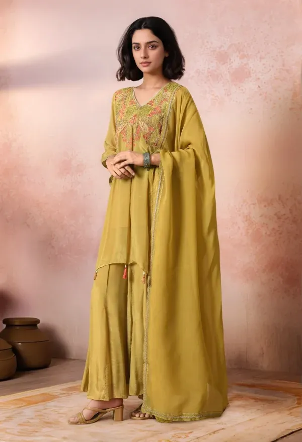 Mehendi green chinnon embroidered sharara set with asymmetric kurta, detailed yoke embroidery, tassel accents, matching sharara, and organza dupatta, offering contemporary festive elegance, Golden Muslin by Jhambthreads.