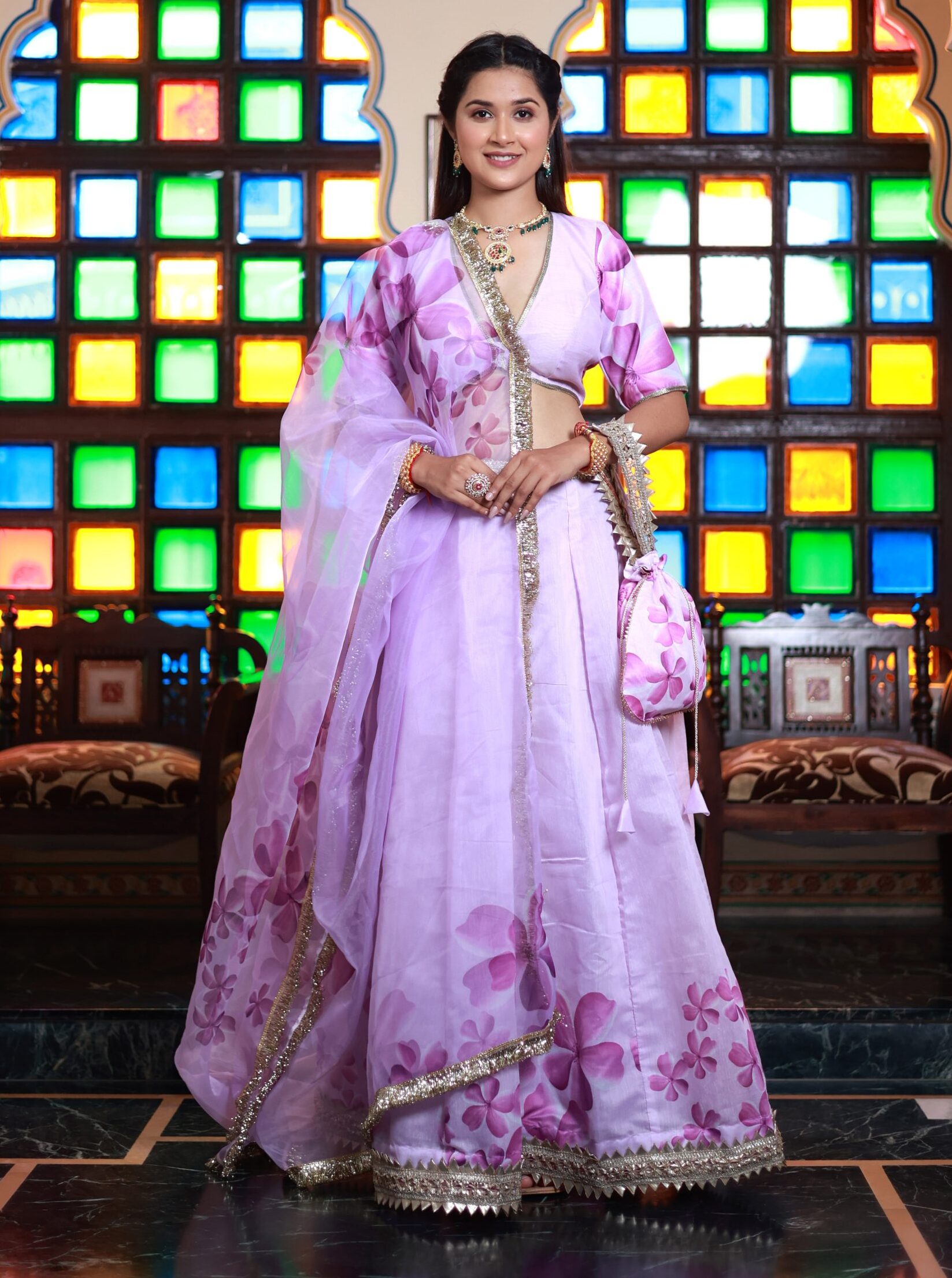 Lavender floral chanderi lehenga with V-neck blouse, organza dupatta, and matching potli from Golden Muslin by Priyanka Rathore.