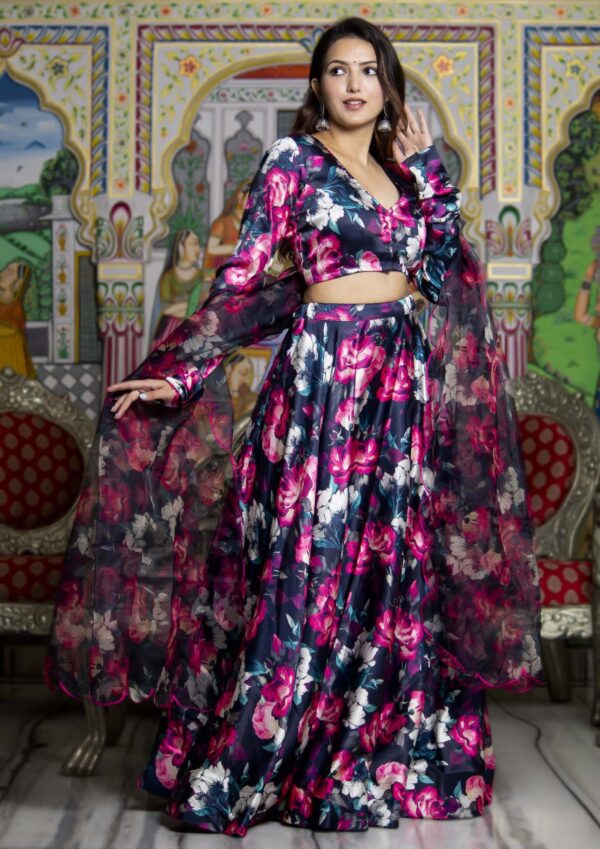 Black satin floral print lehenga set with padded blouse featuring white and pink floral prints, full churidar sleeves, voluminous satin lehenga, and black organza floral dupatta with scalloped edge detailing in Golden Muslin by Priyanka Rathore