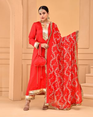 Red Uppada silk straight kurta set with gota detailing on yoke, sleeves, hem, matching pants with gota work, and heavily embroidered dupatta with gota borders and potli in Golden Muslin by Priyanka Rathore