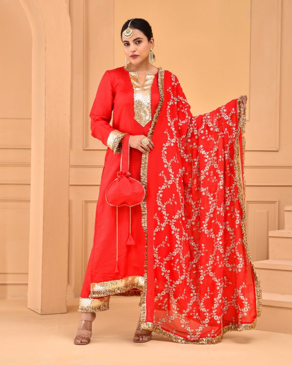 Red Uppada silk straight kurta set with gota detailing on yoke, sleeves, hem, matching pants with gota work, and heavily embroidered dupatta with gota borders and potli in Golden Muslin by Priyanka Rathore