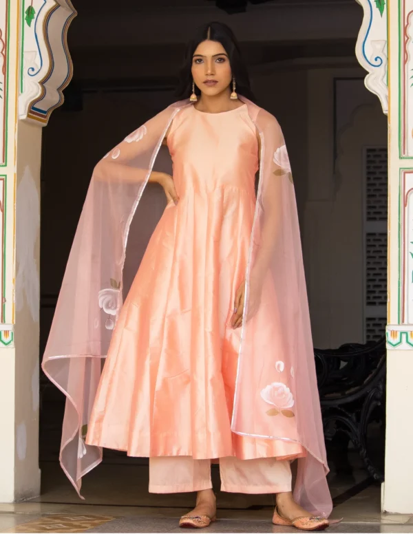 Peach taffeta silk long-length kali-pattern anarkali with palazzo and hand-painted organza dupatta from Golden Muslin by Priyanka Rathore.