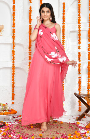 Pink georgette floor-length Anarkali set with scoop neckline and noodle straps, paired with hand-painted floral print pink georgette dupatta finished with lace border detailing in Golden Muslin by Priyanka Rathore