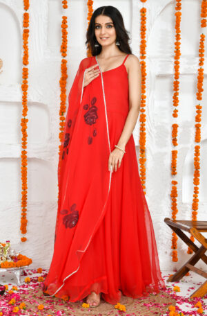 Red georgette floor-length Anarkali set with scoop neckline and noodle straps, paired with hand-painted floral print georgette dupatta finished with lace border detailing in Golden Muslin by Priyanka Rathore
